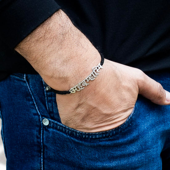 Silver Sanskrit inscription bracelet worn on wrist, unisex spiritual accessory