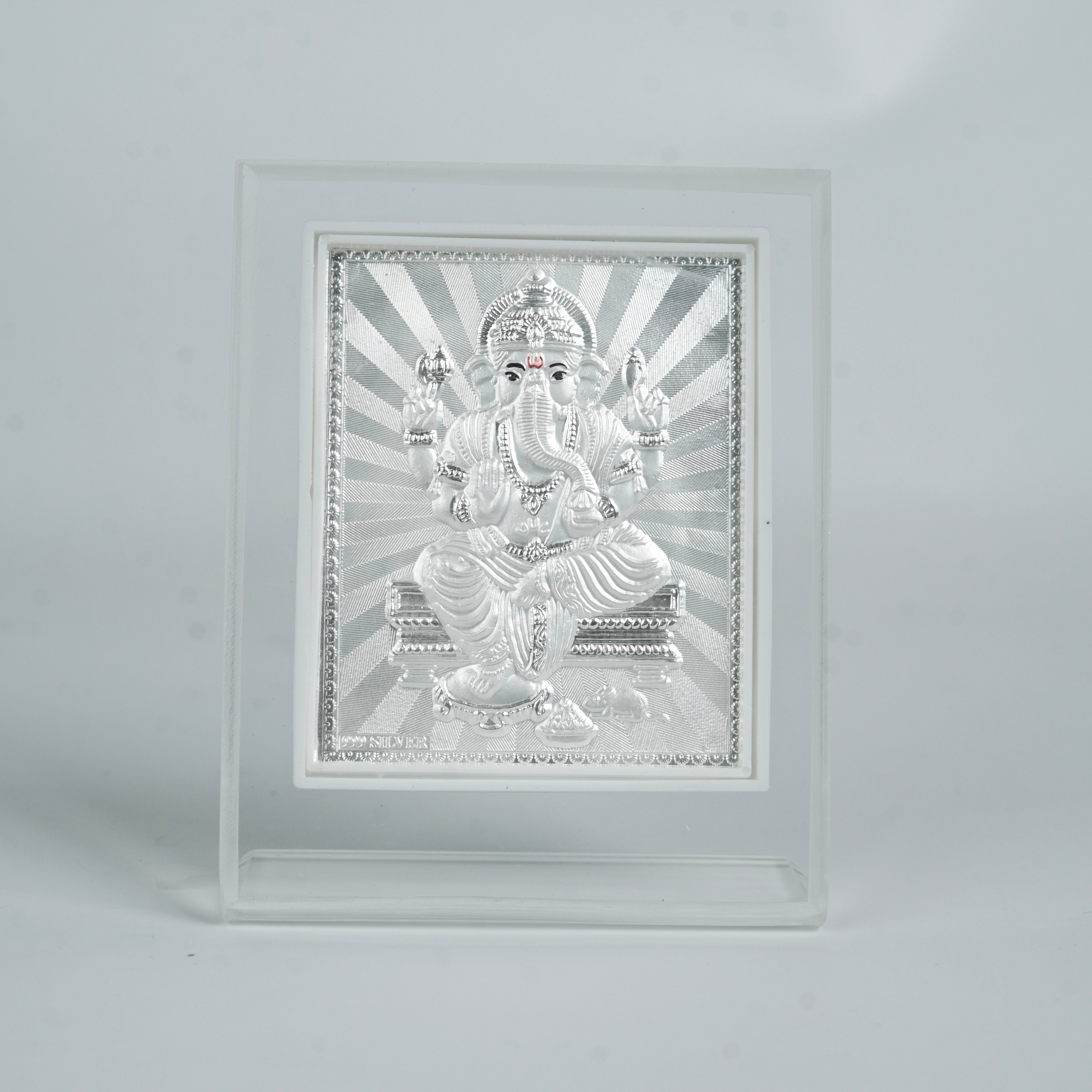 Silver Ganesh deity in white frame for pooja and home decoration