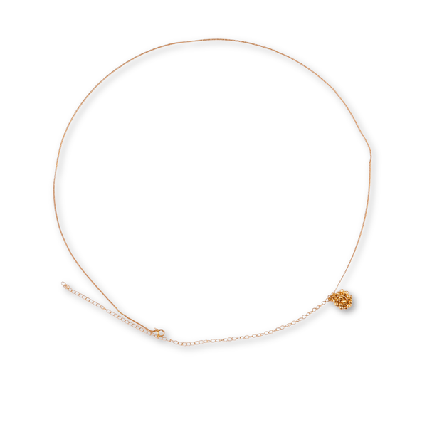 Close-up of gold chain with floral pendant