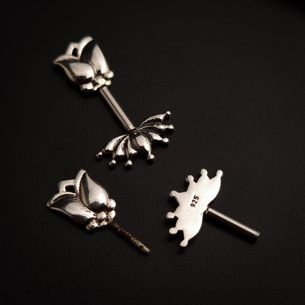 a pair of silver ear studs on a black surface