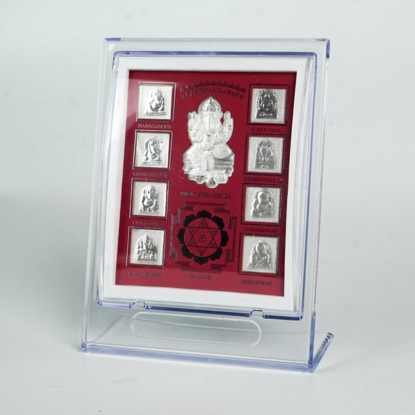 Close-up of silver Ganesh Yantra frame with red background and detailed silver images