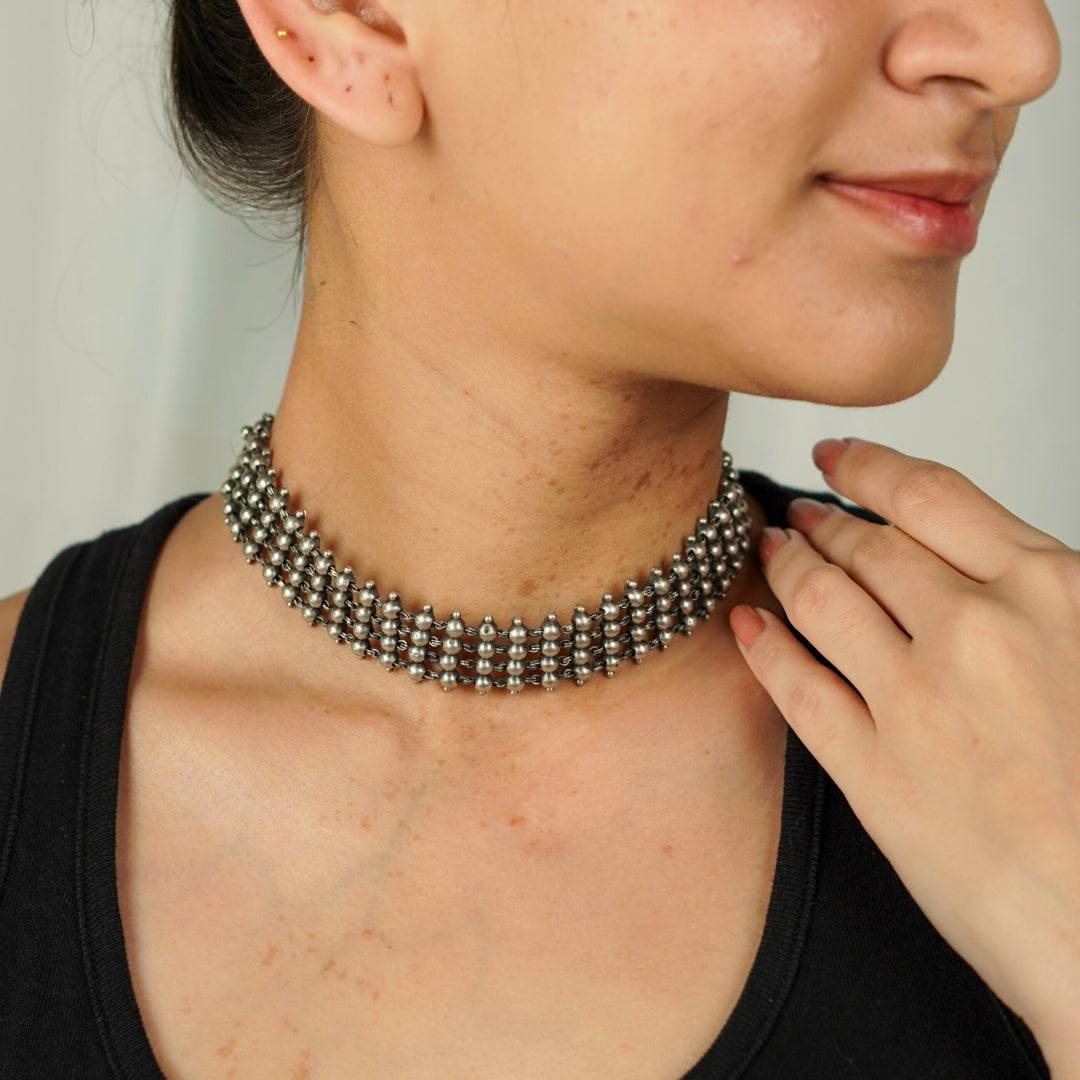 Silver oxidized choker necklace worn on a woman