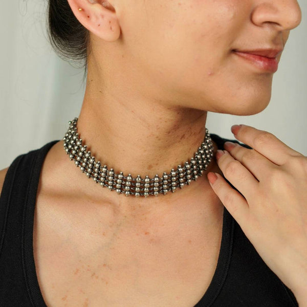 Silver oxidized choker necklace worn on a woman