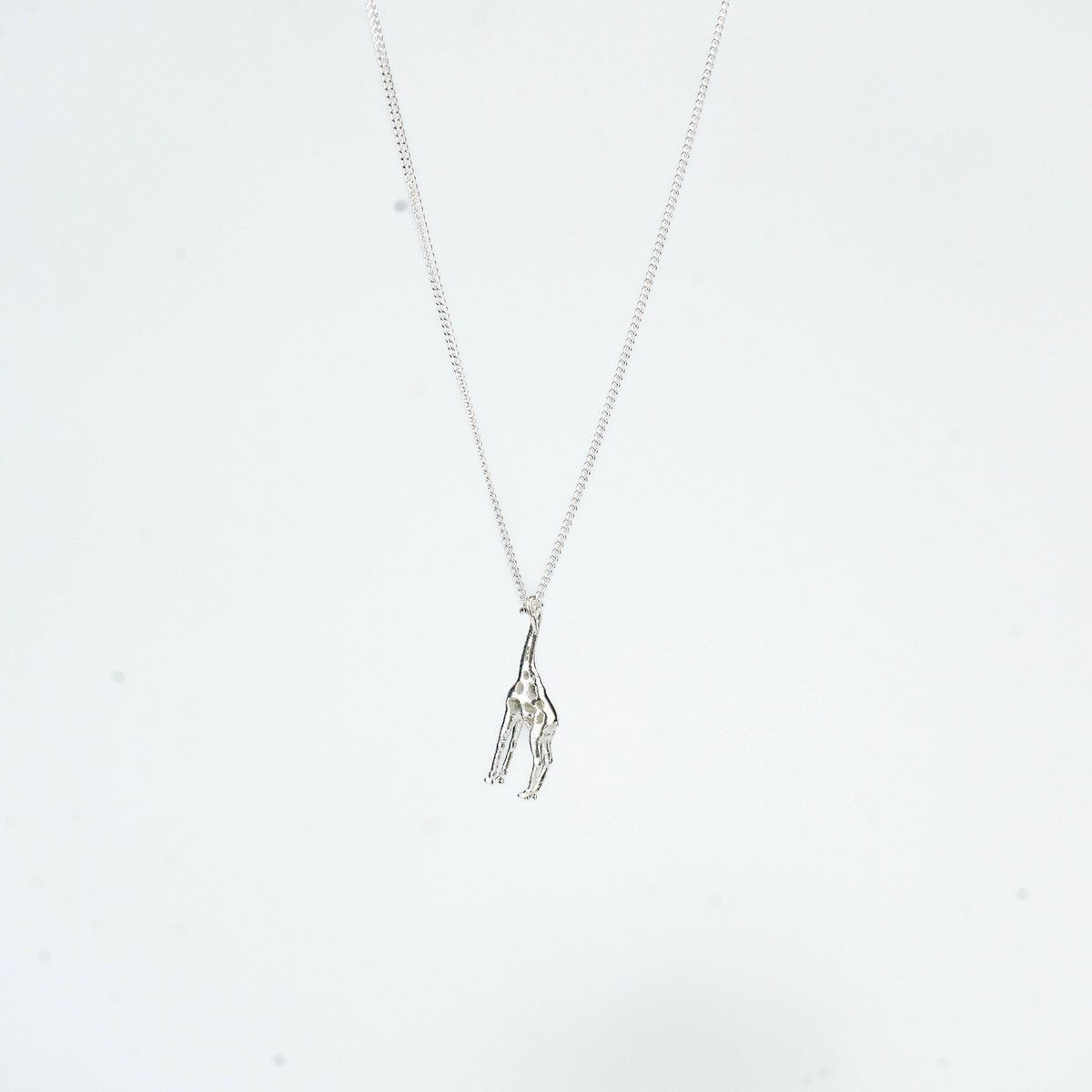 Close-up of silver giraffe pendant necklace