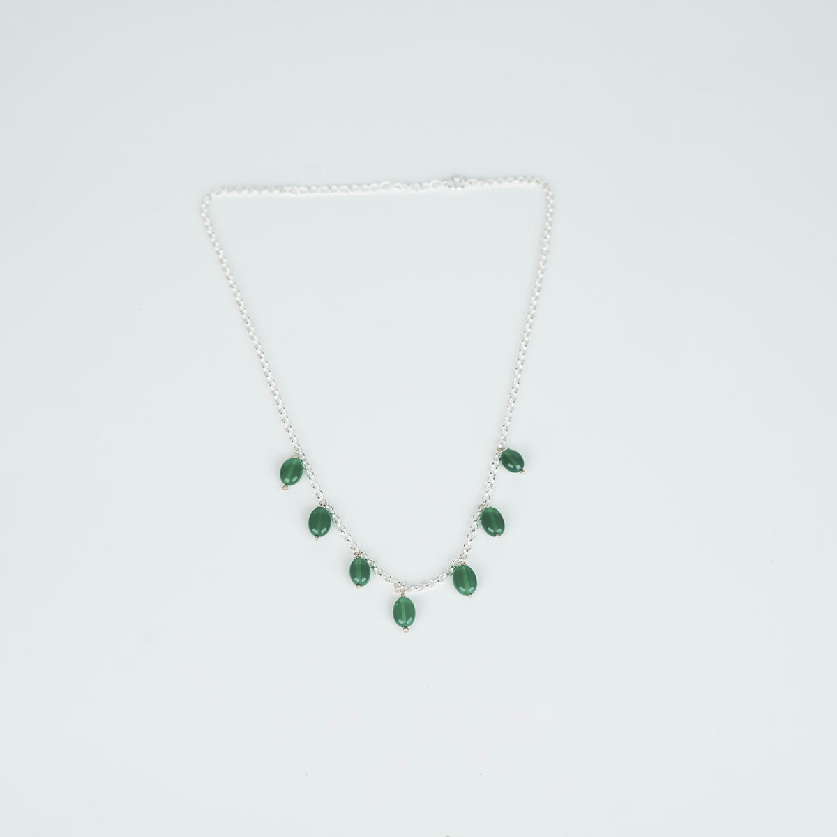 Detail shot of green onyx setting in silver chain