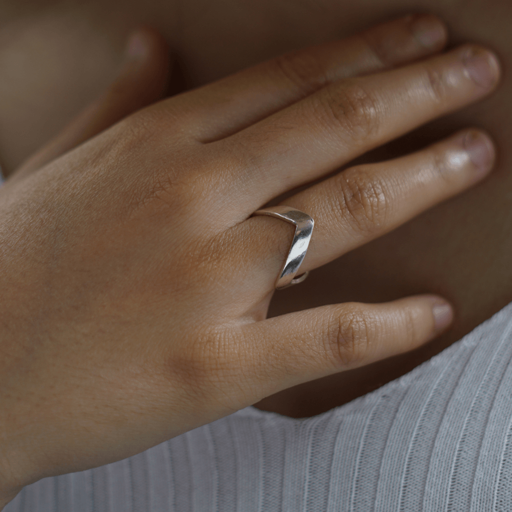 Minimalist silver ring on finger