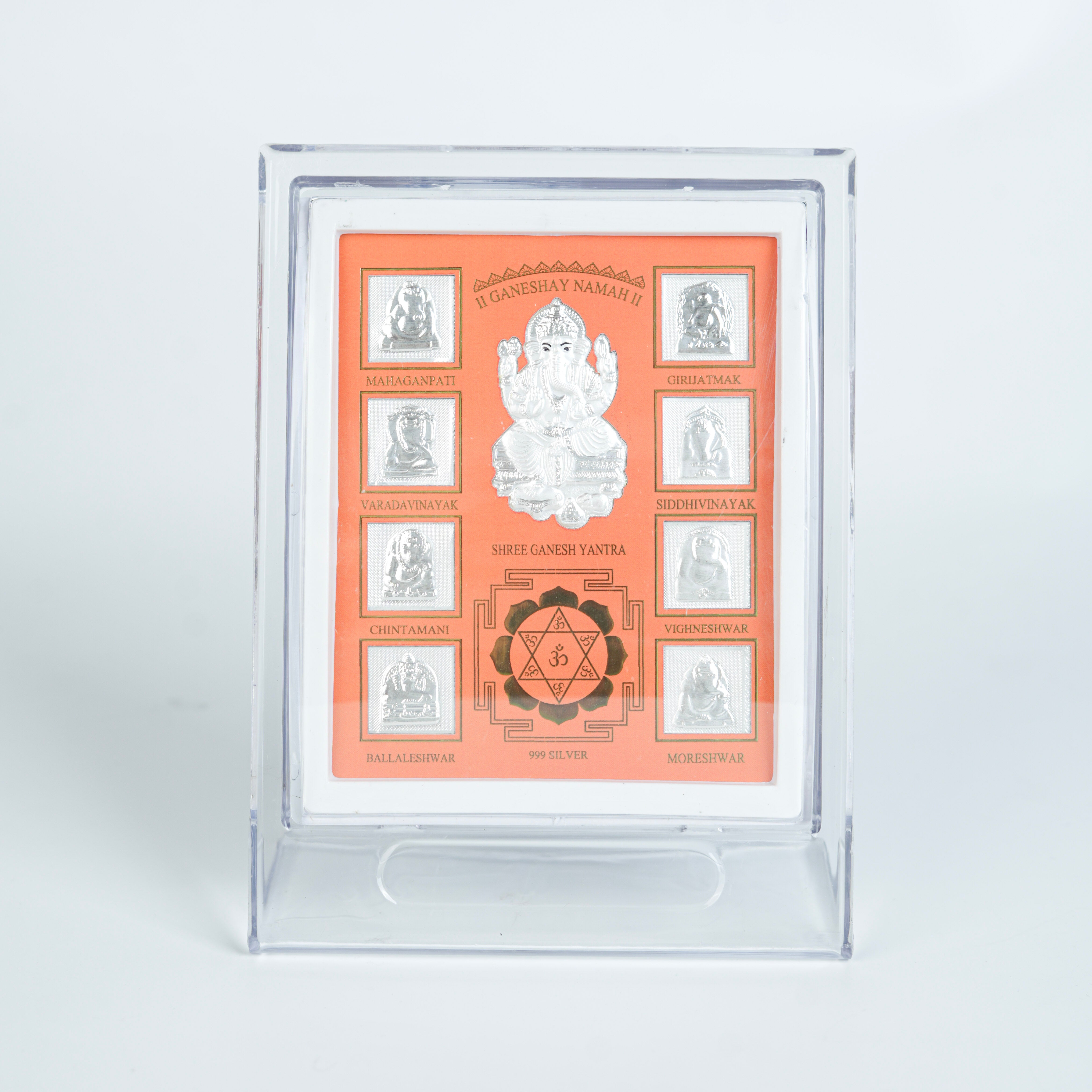Close-up of silver Ganesh Yantra frame with detailed design and orange background