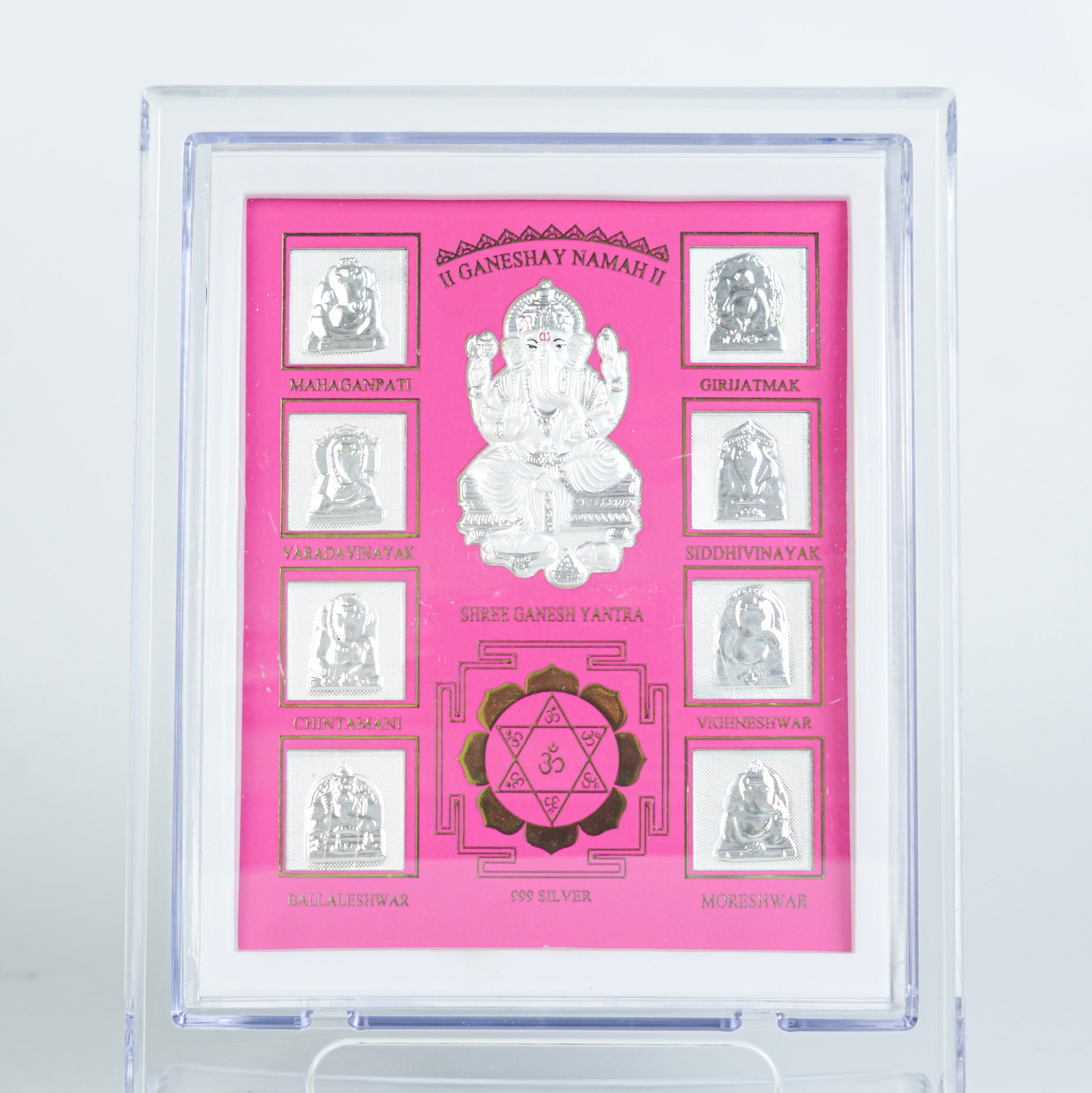 Close-up of silver Ganesh Yantra in pink frame