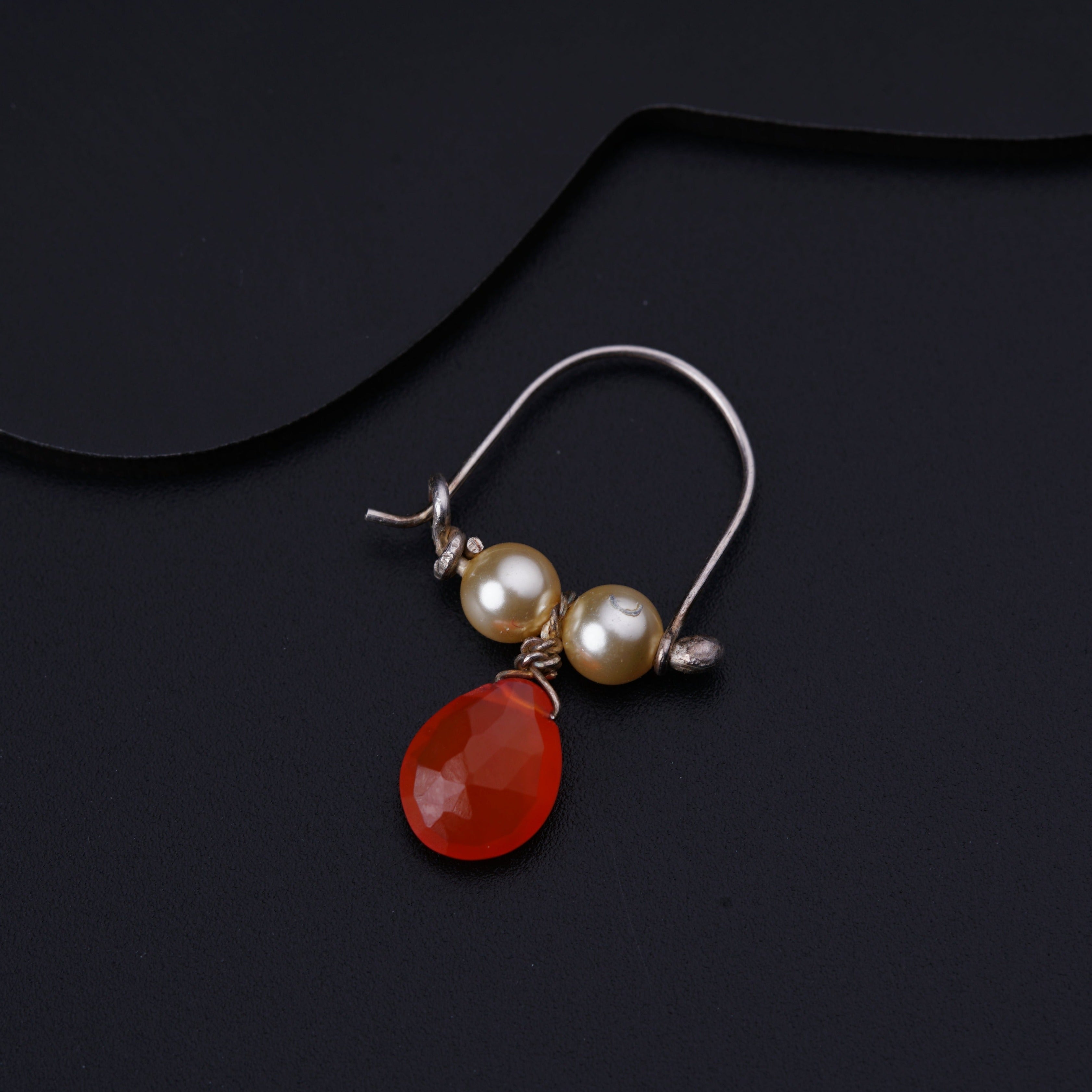 a pair of red and white earrings with pearls
