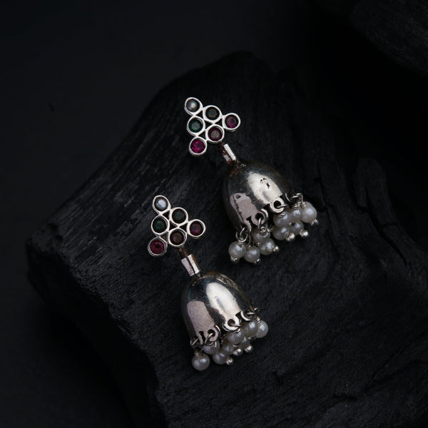 a pair of silver bells on a rock