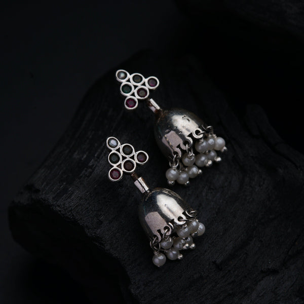 a pair of silver bells with pearls on them