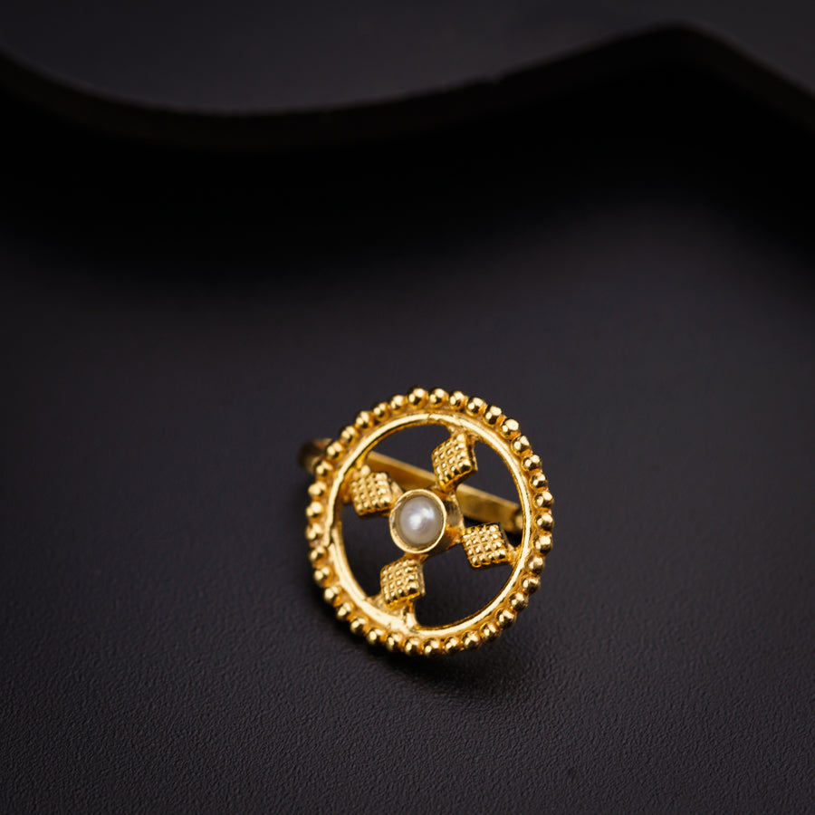 a gold brooch with a pearl in the center
