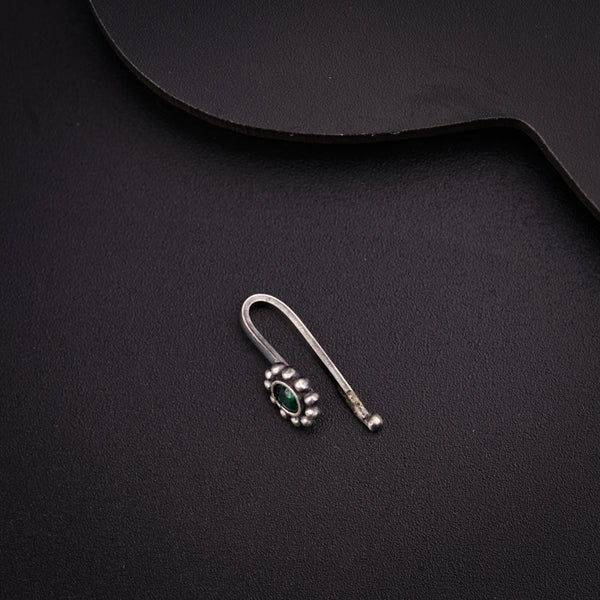 a pair of earrings sitting on top of a black surface