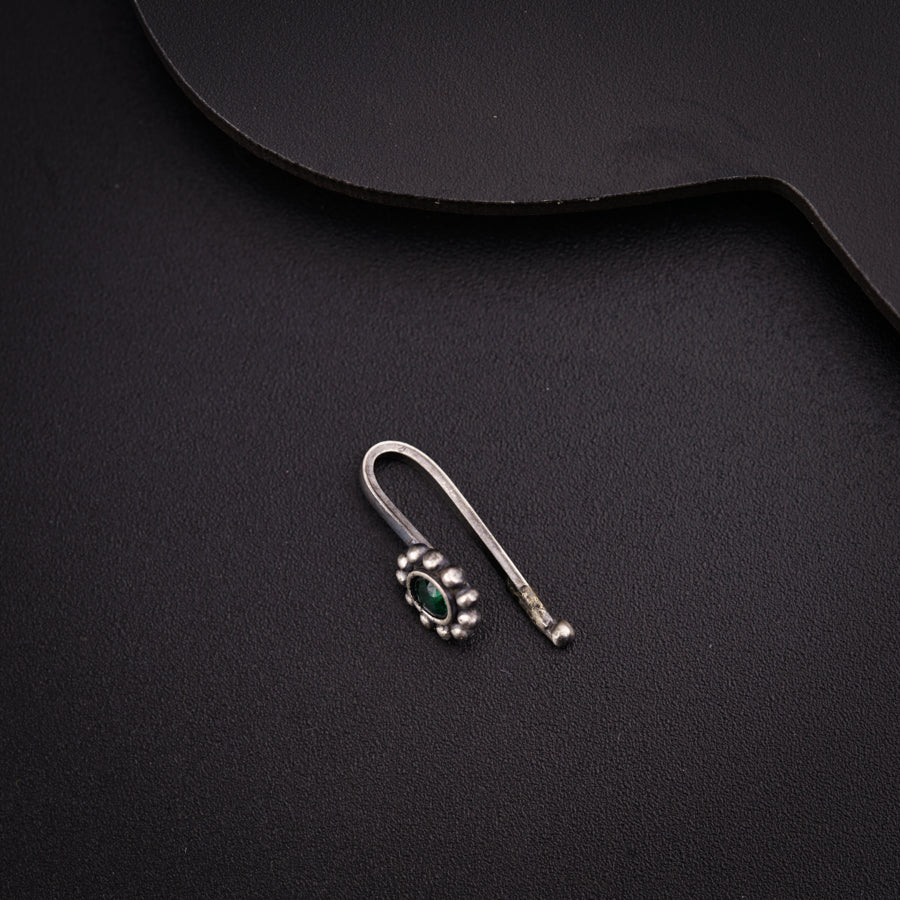 a pair of earrings sitting on top of a black surface