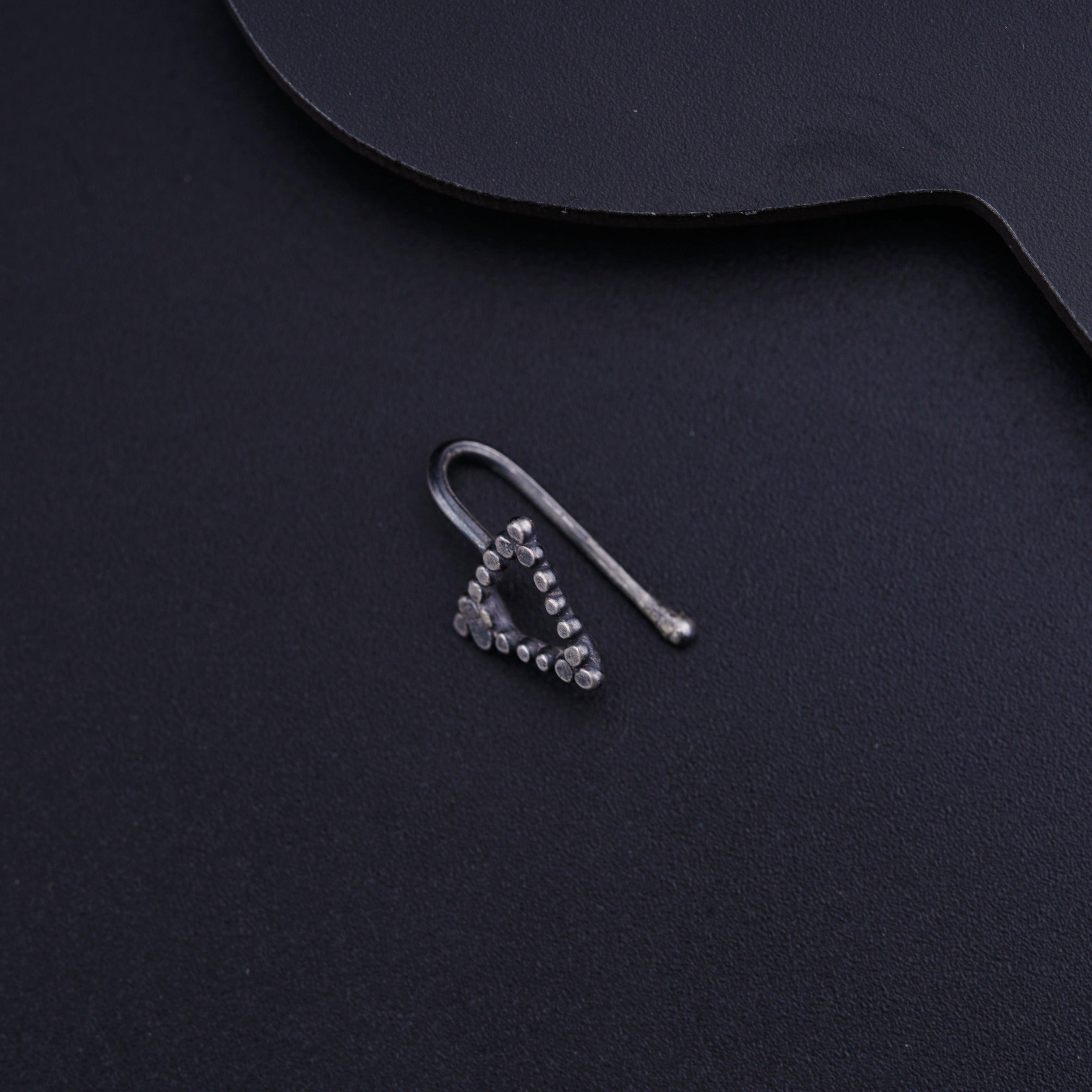 a pair of earrings sitting on top of a black surface