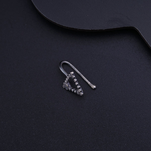 a pair of earrings sitting on top of a black surface