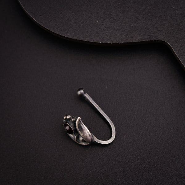 a pair of scissors and a hook on a black surface