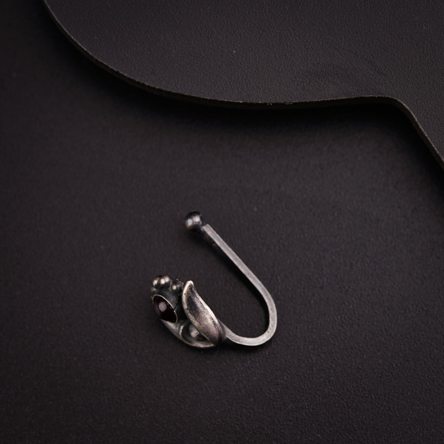 a pair of scissors and a hook on a black surface