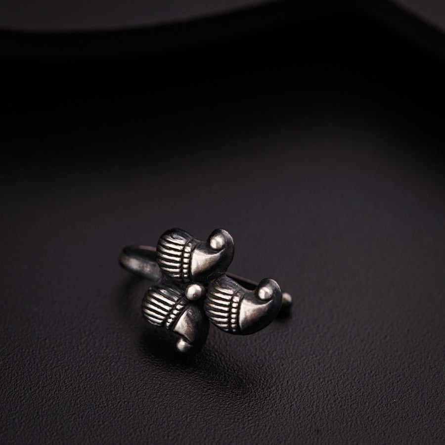 a silver ring sitting on top of a black surface