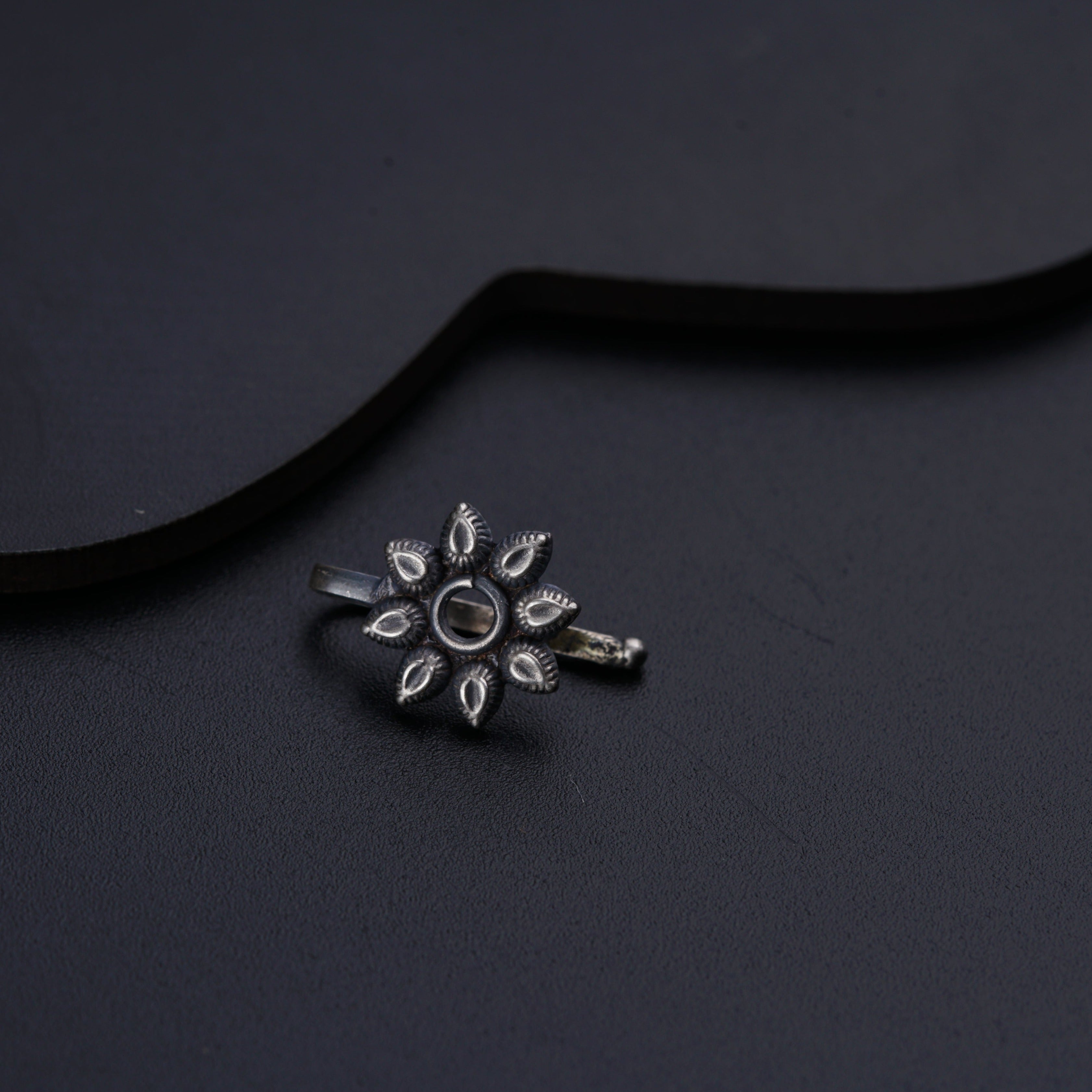 a silver ring with a flower design on it