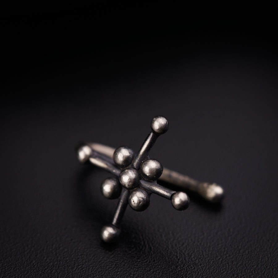 a cross made out of metal balls on a black surface