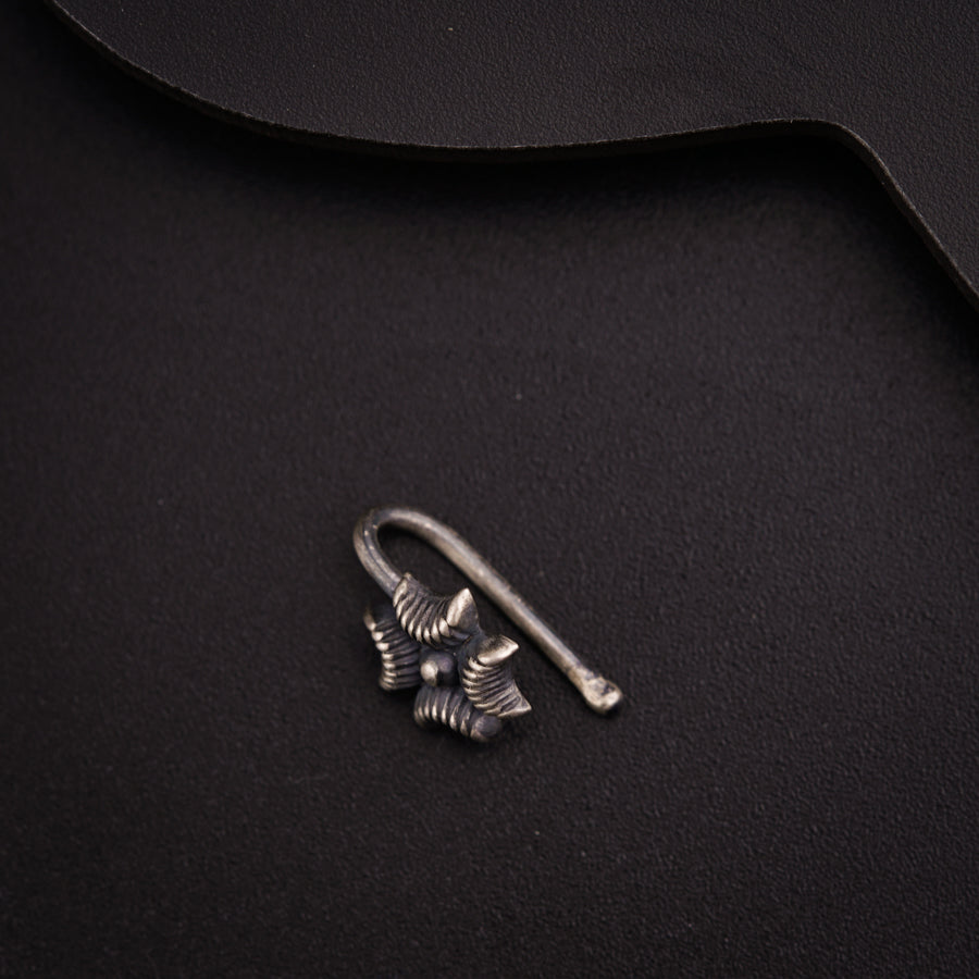 a pair of earrings sitting on top of a black surface