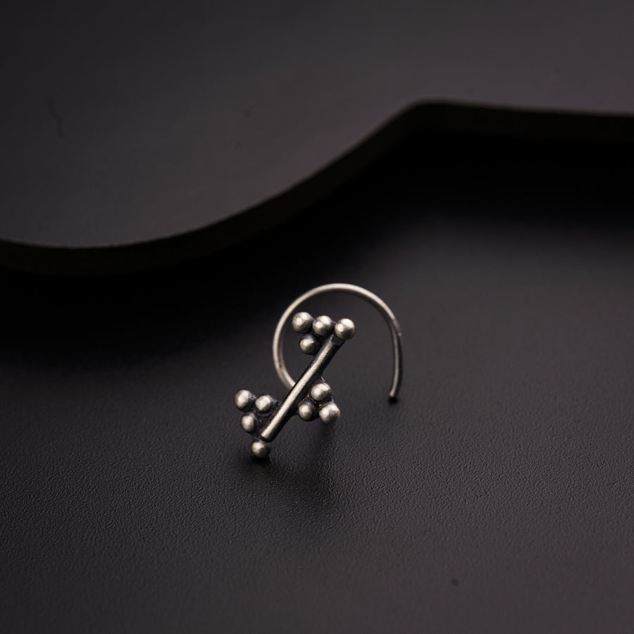 a pair of earrings sitting on top of a black surface