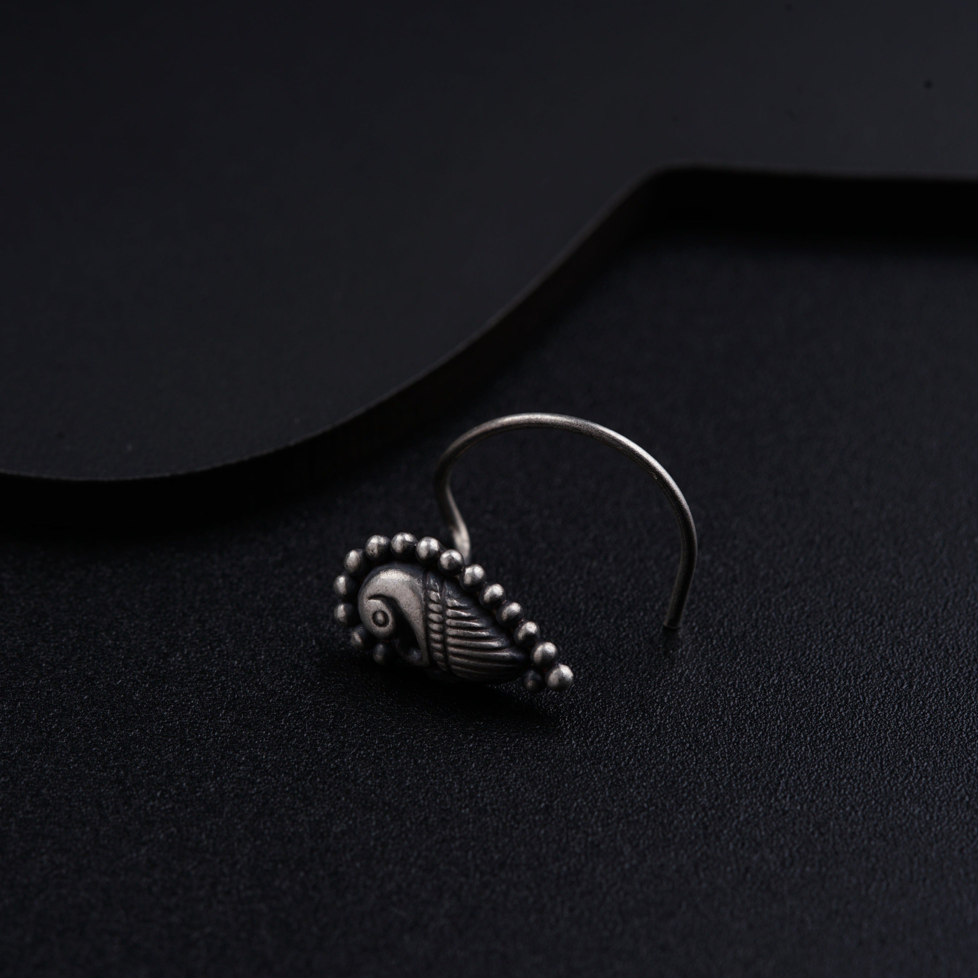 a close up of a pair of earrings on a black surface