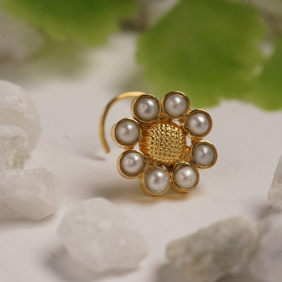 a close up of a ring with pearls
