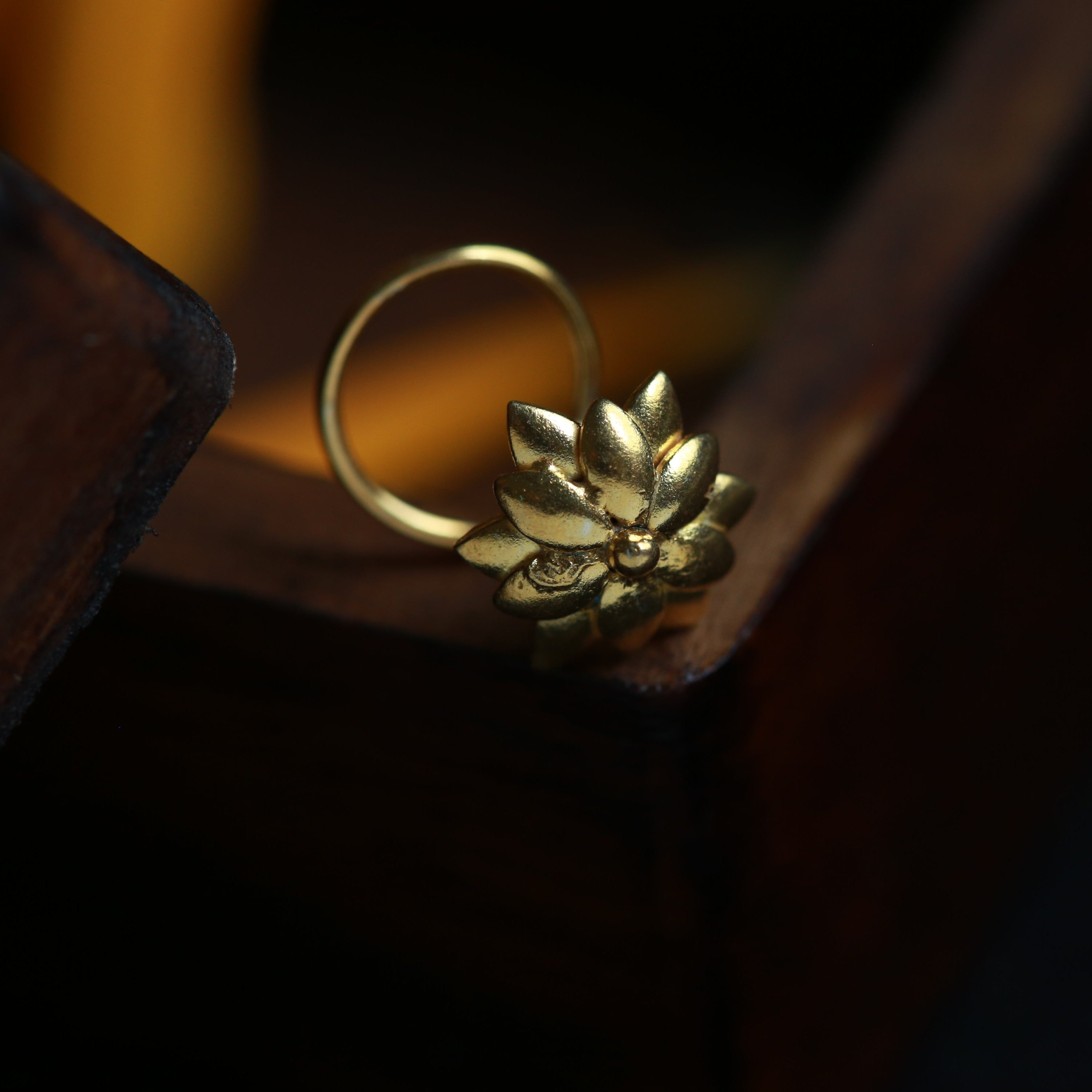 a gold ring with a flower on top of it