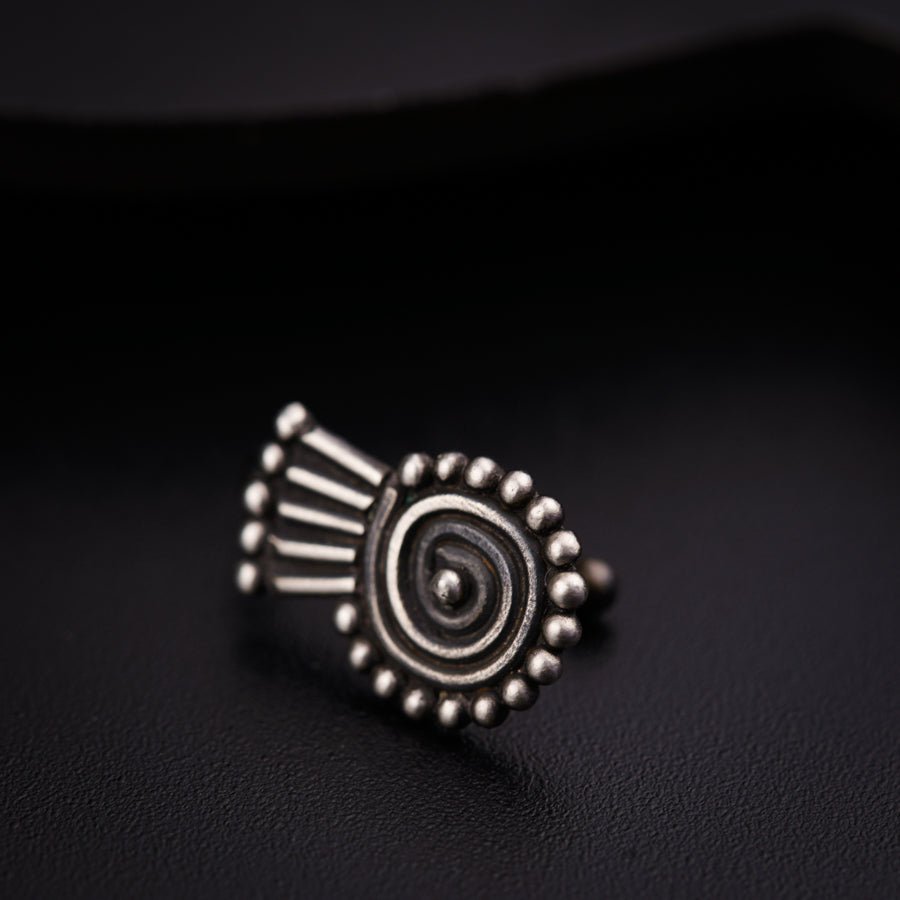 a silver ring sitting on top of a black surface