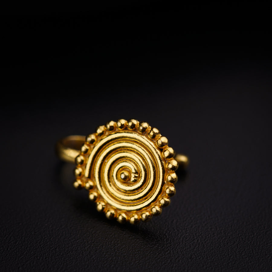 a gold ring sitting on top of a black surface