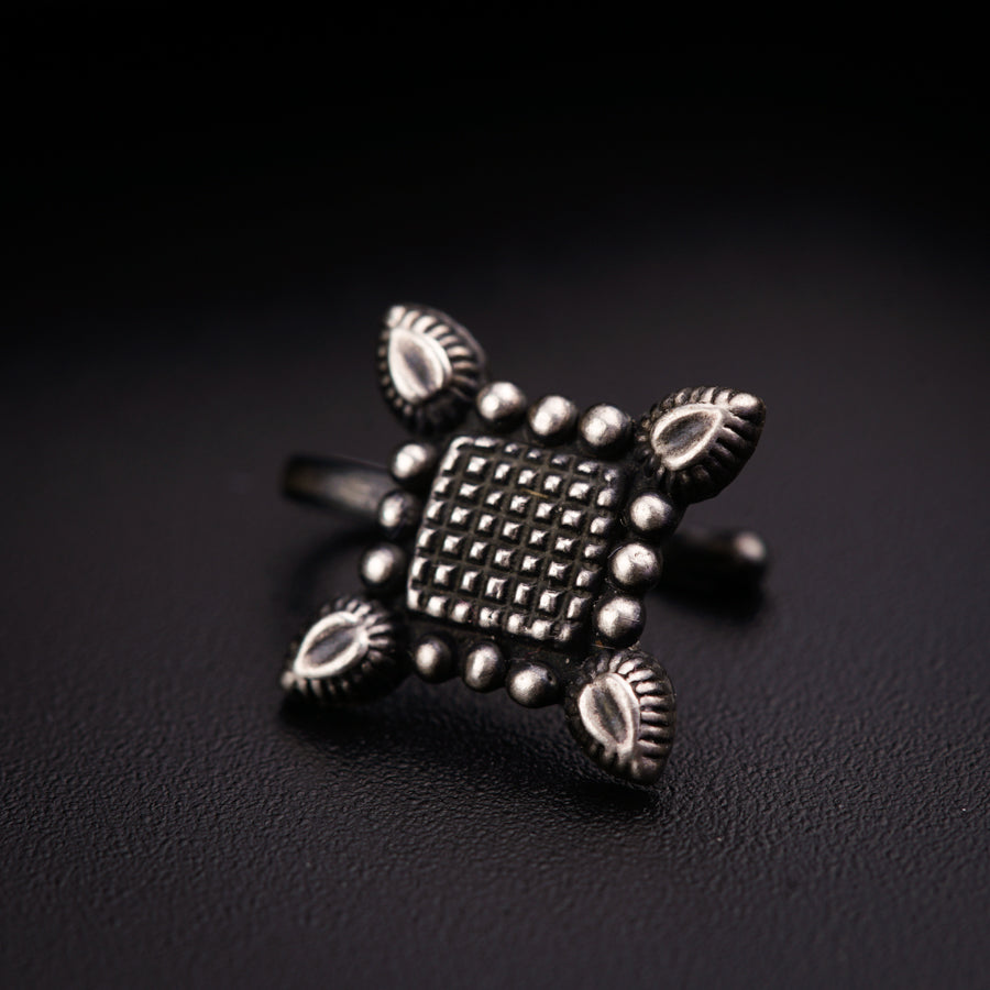 a silver ring on a black surface