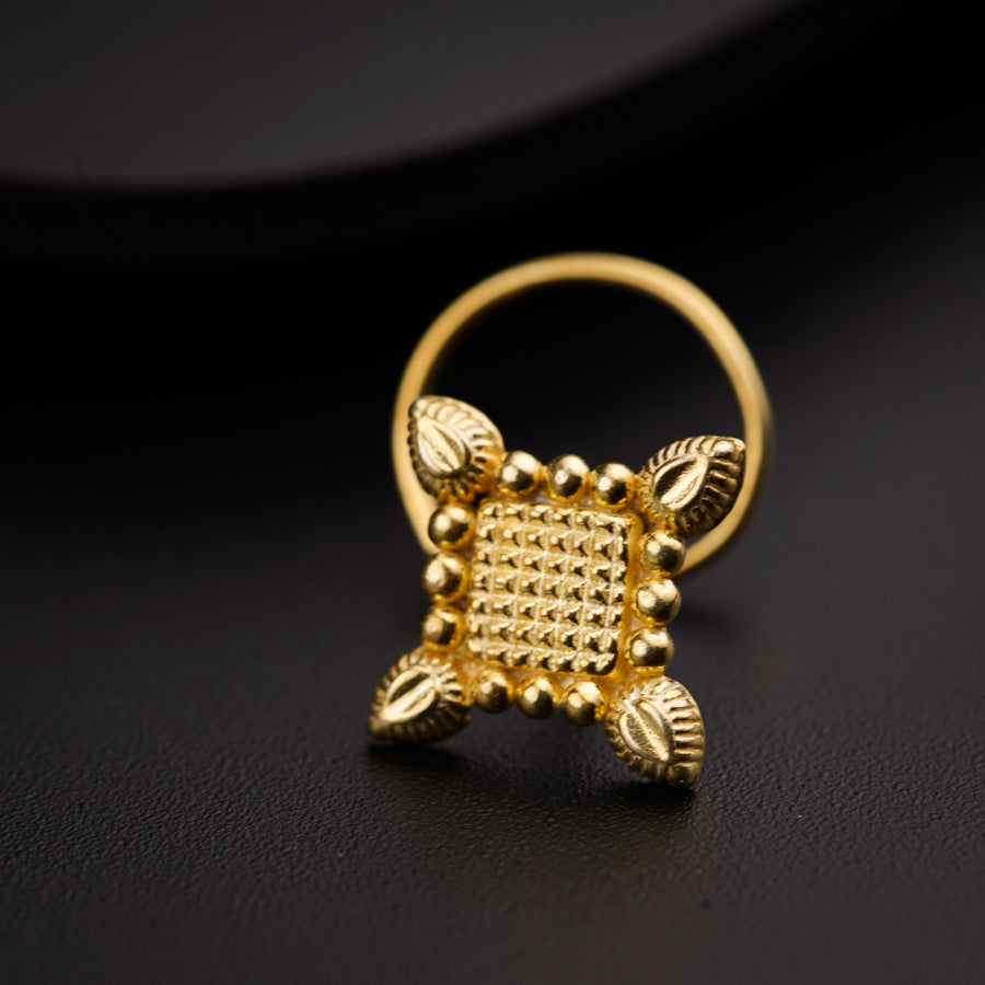 a close up of a gold ring on a black surface