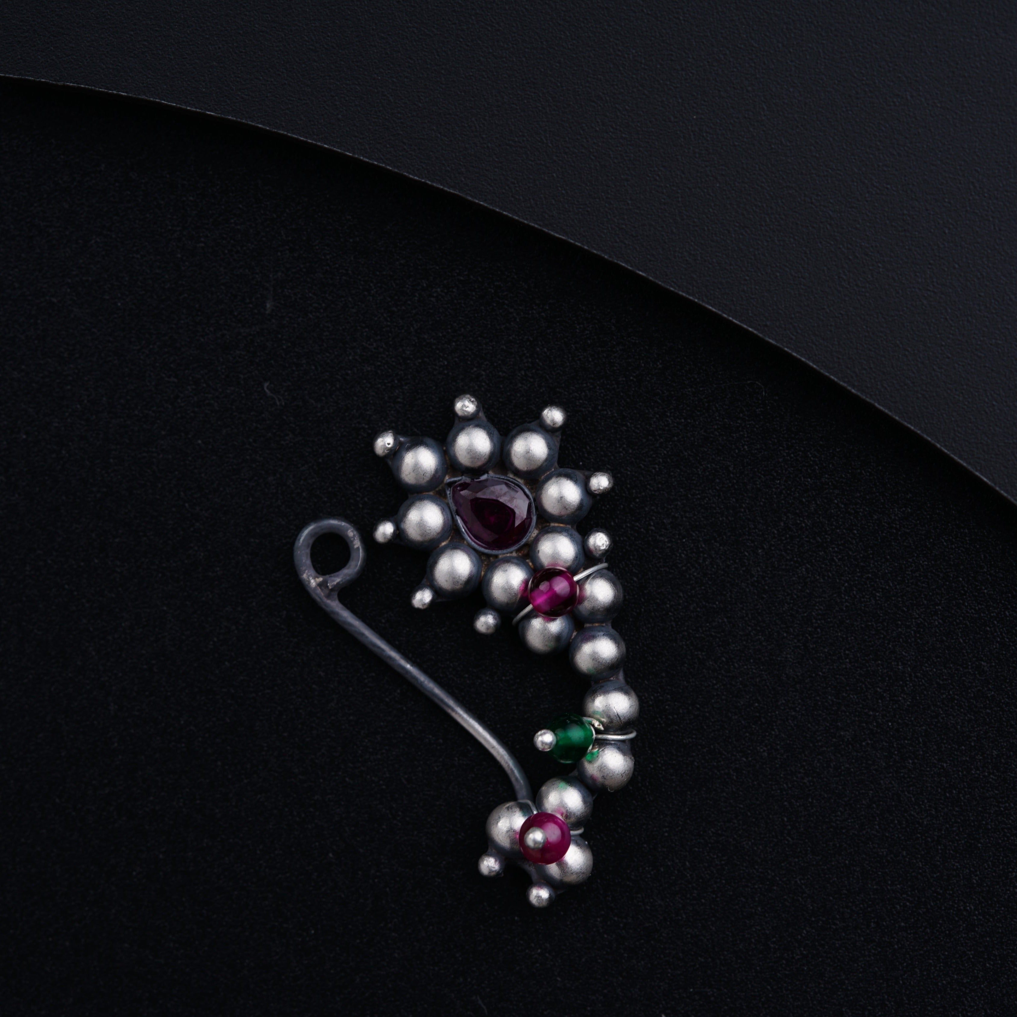 a close up of a brooch on a black surface