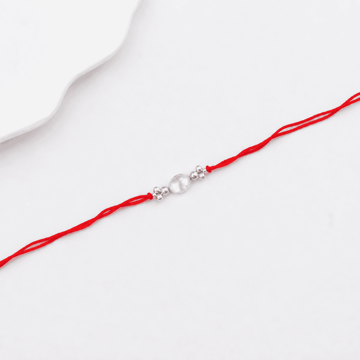 Elegant baroque pearl Rakhi with silver beads for brother