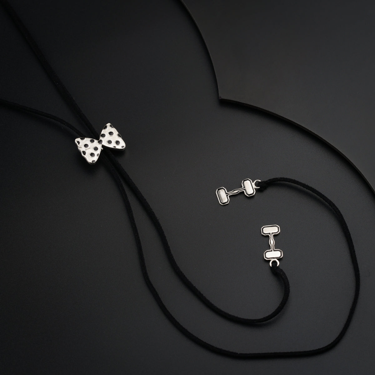 a pair of earrings and a necklace on a black surface