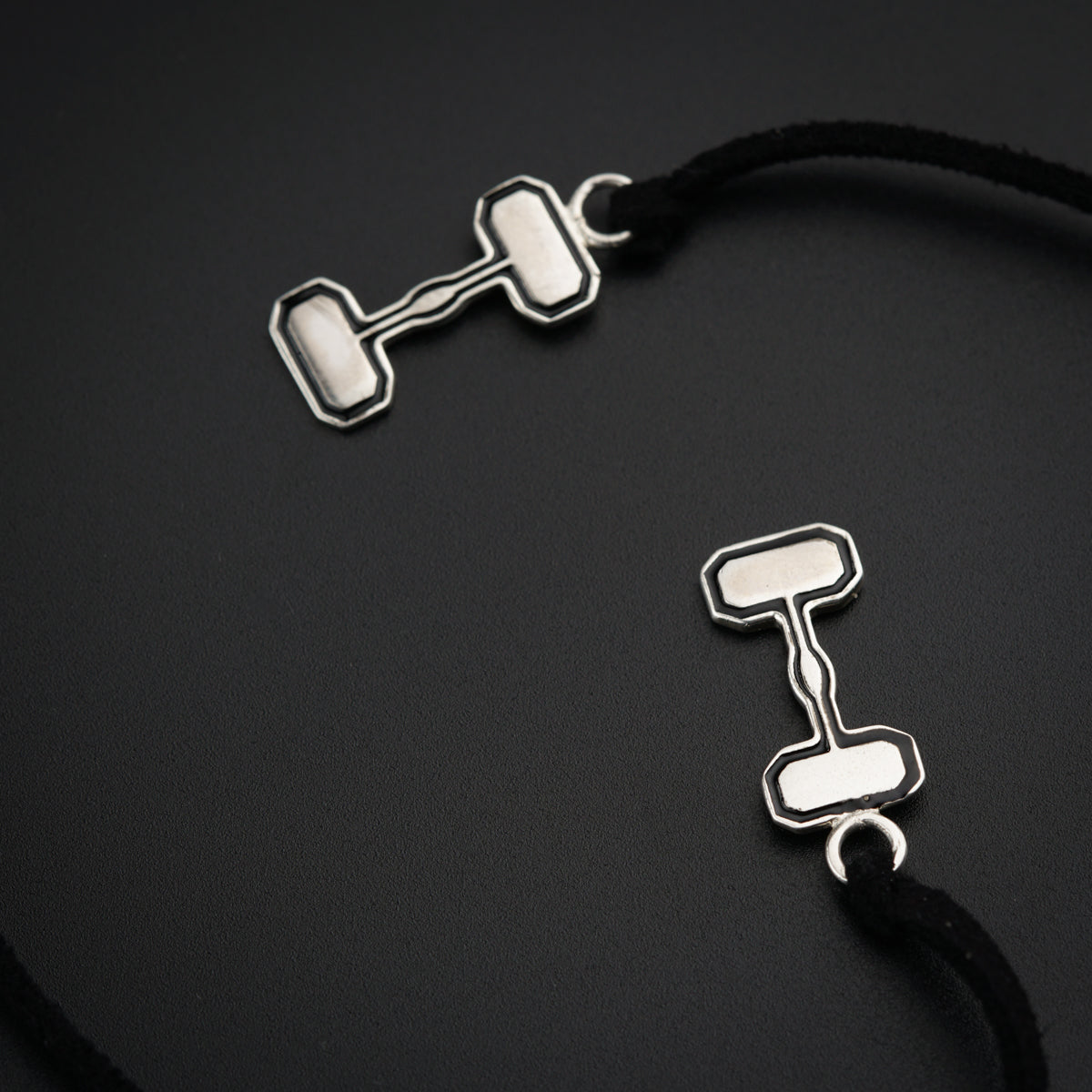 a pair of silver earrings on a black background