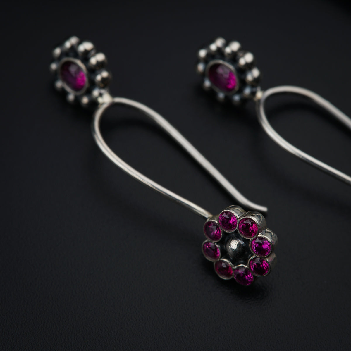 a pair of silver earrings with pink stones