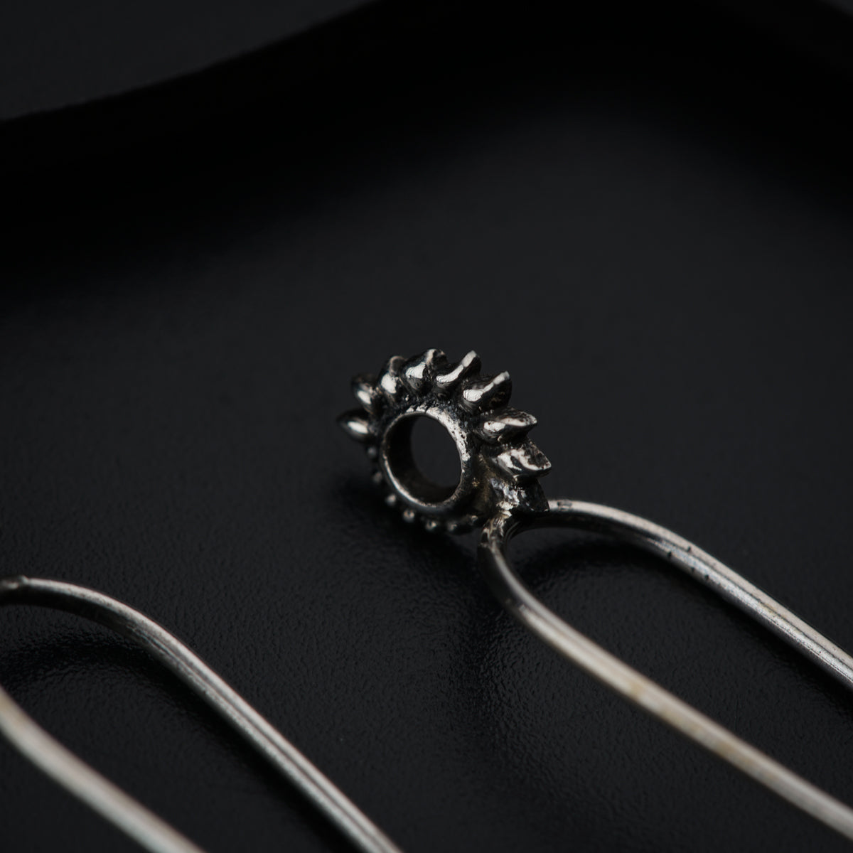 a pair of metal tongs sitting on top of a black surface