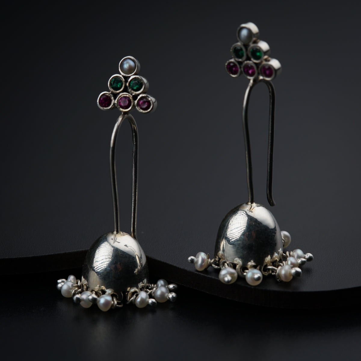 a pair of earrings with pearls and stones