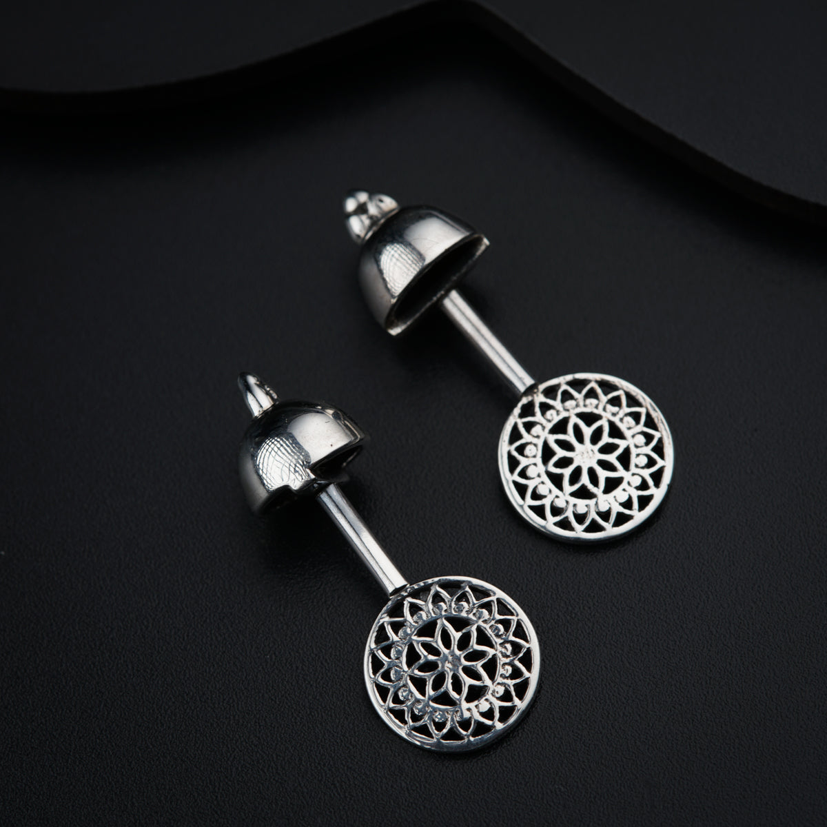 a pair of earrings with a circular design on them