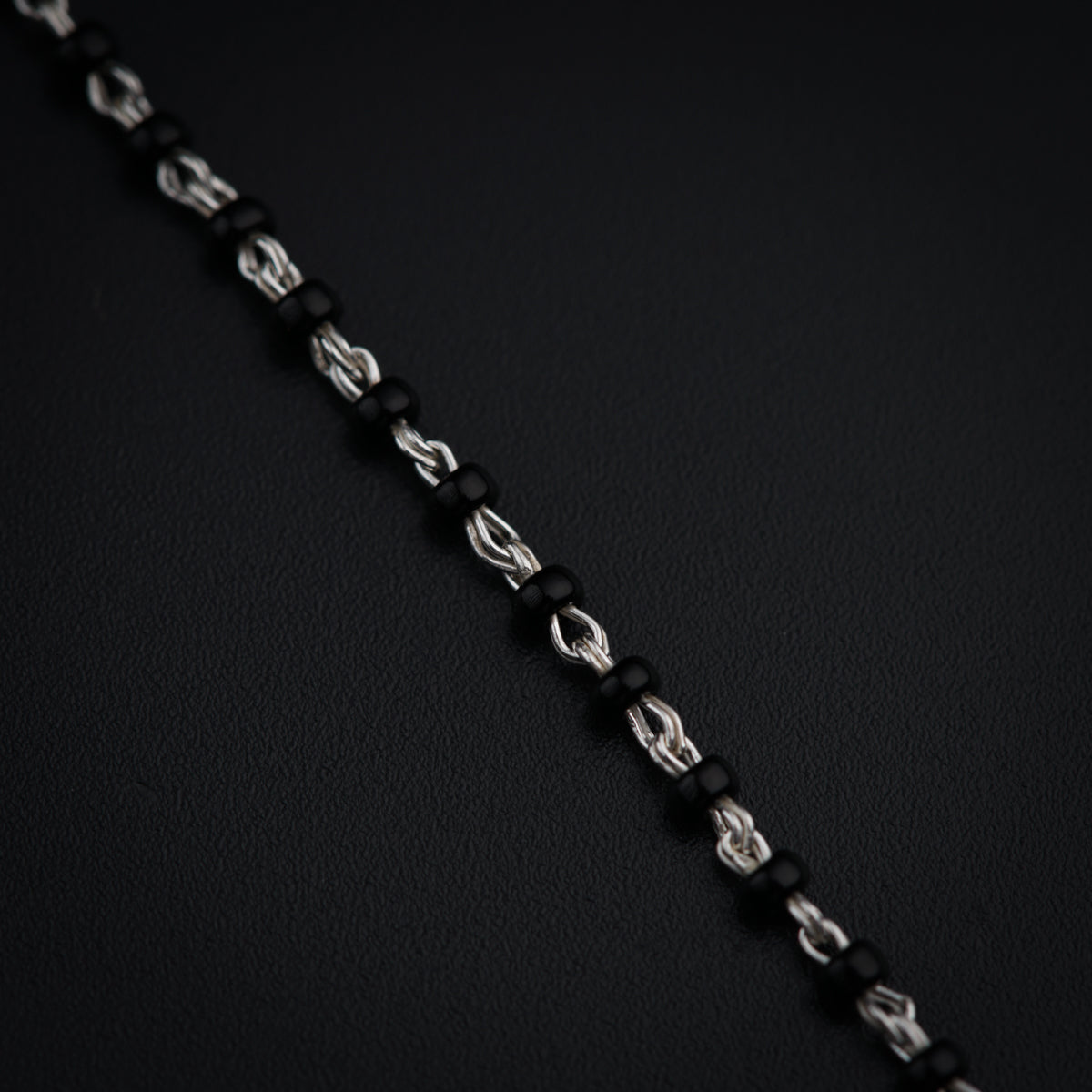 a close up of a chain on a black surface