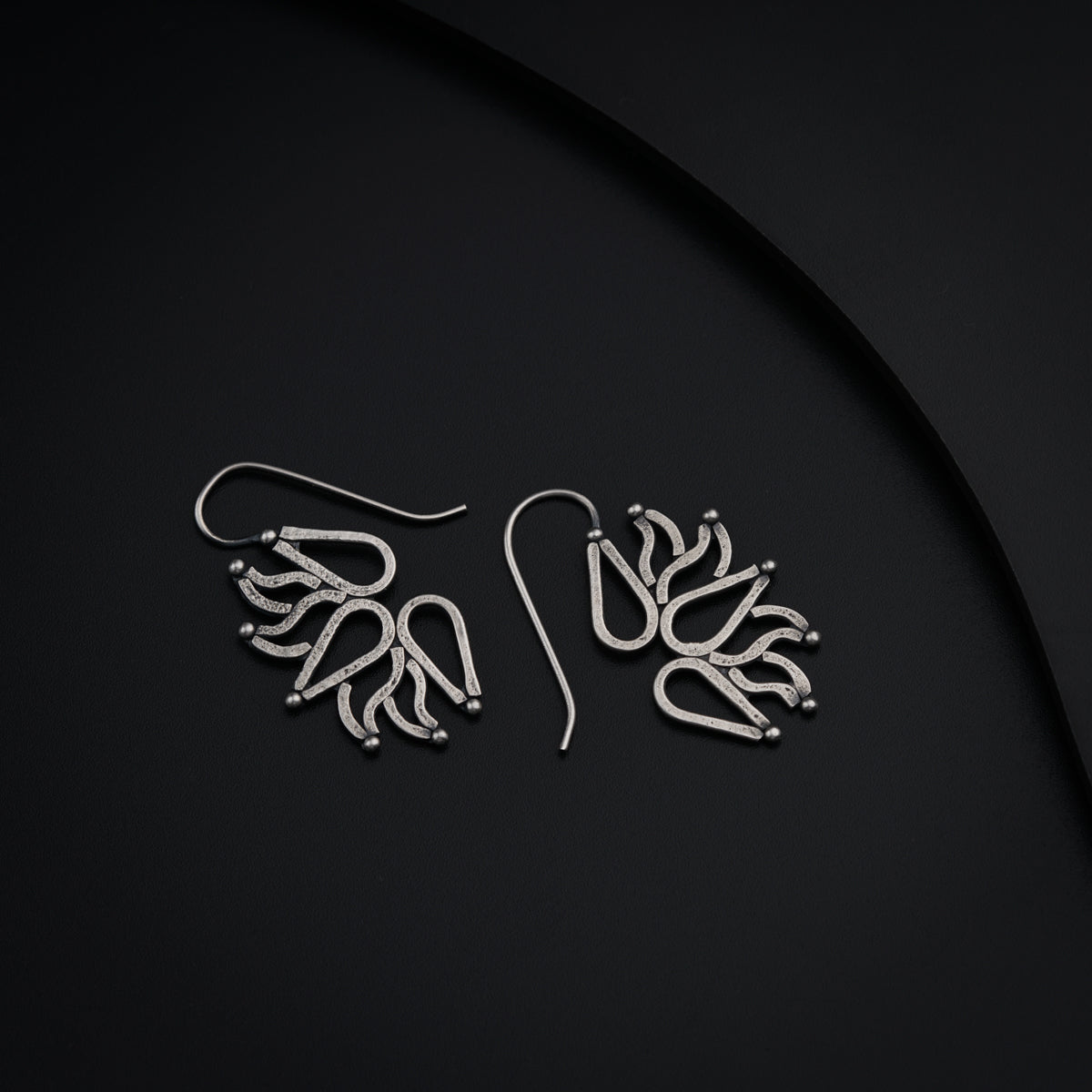 a pair of earrings on a black surface