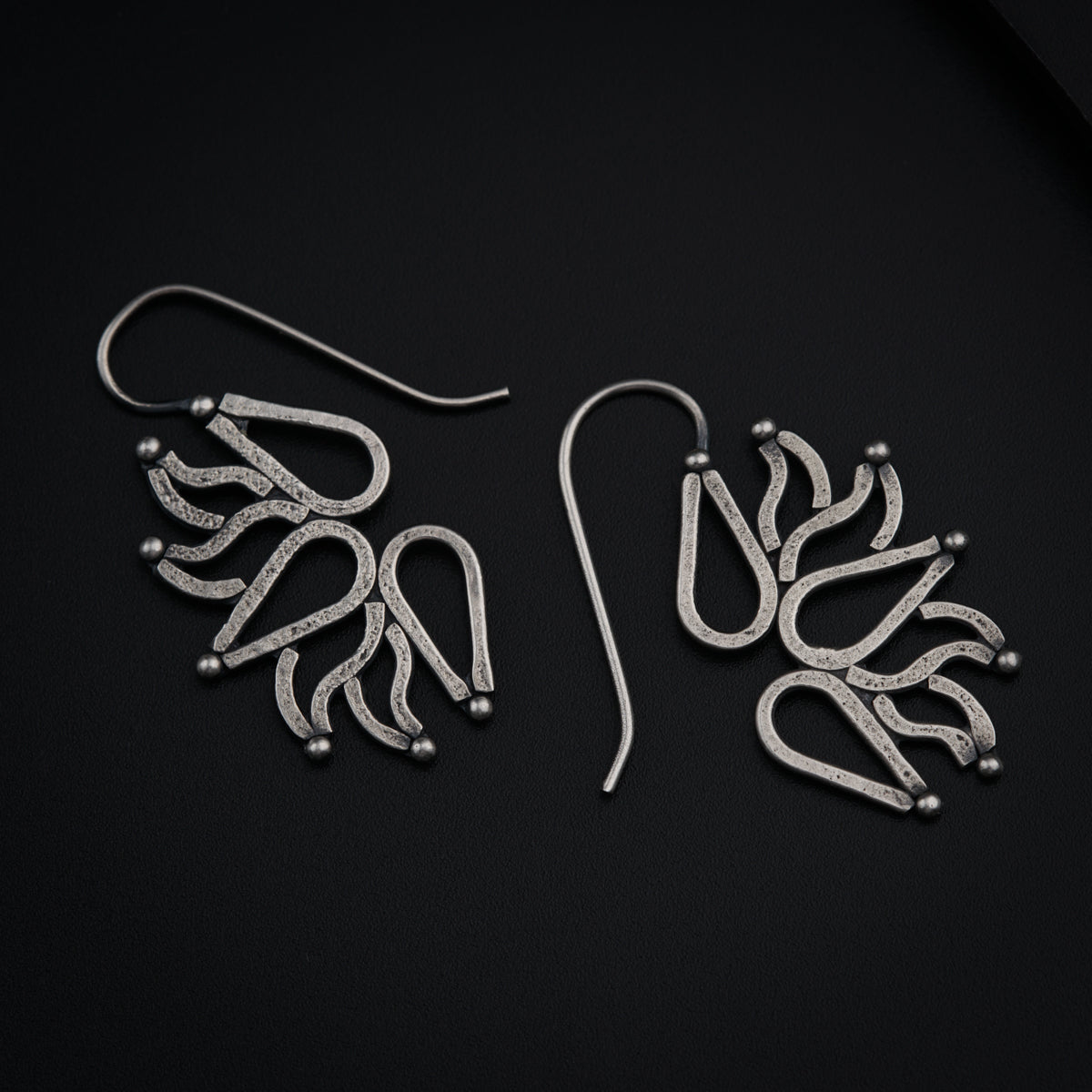 a pair of earrings on a black surface