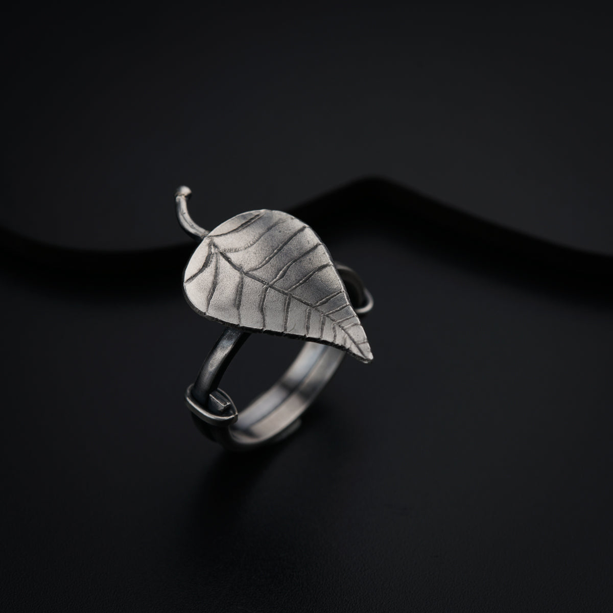 a silver ring with a leaf on it