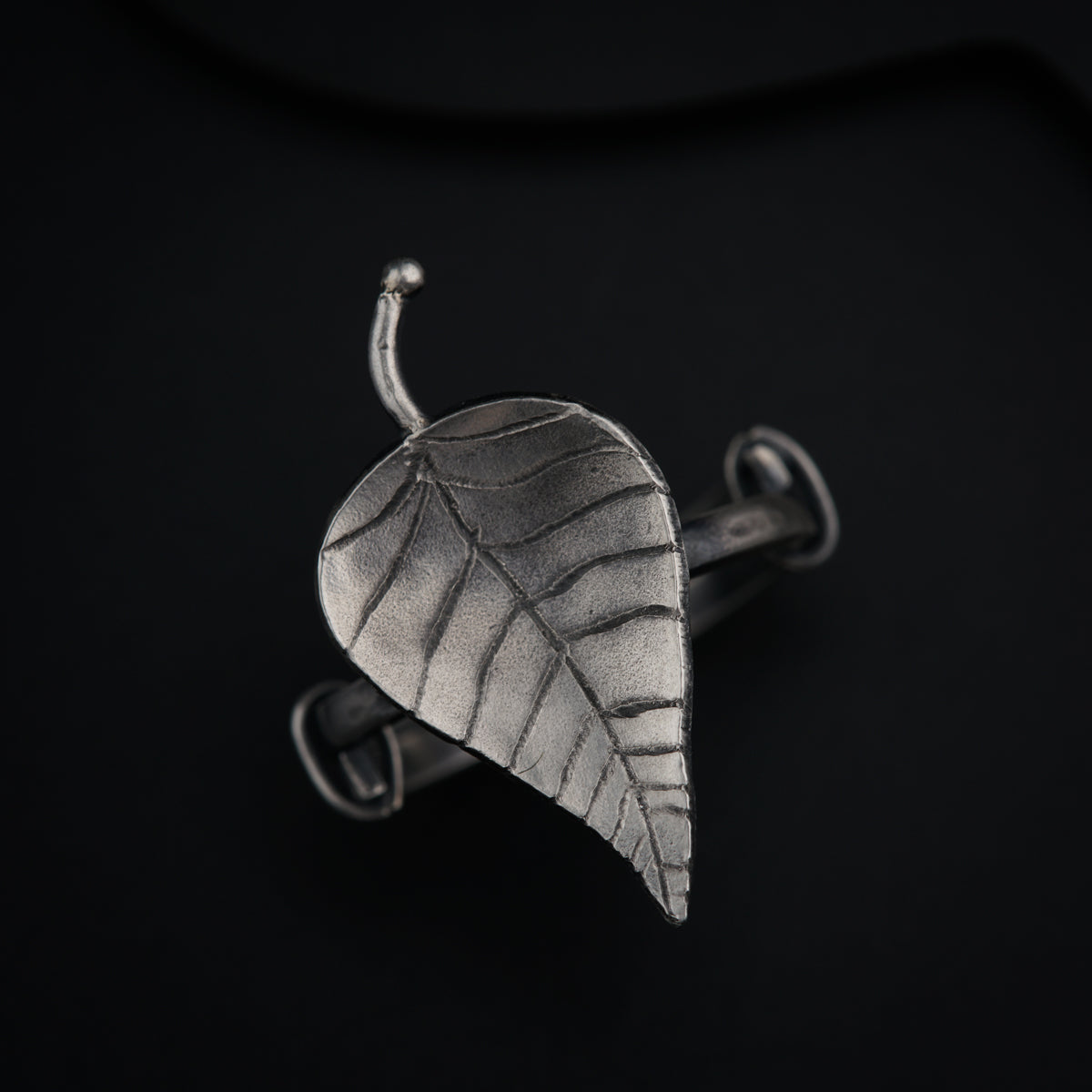 a metal object with a leaf on it