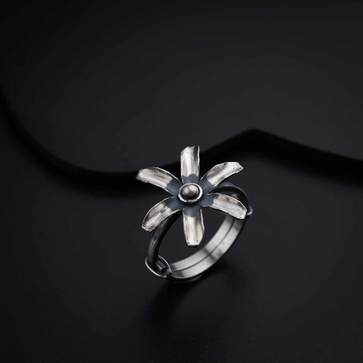 a silver ring on a black surface