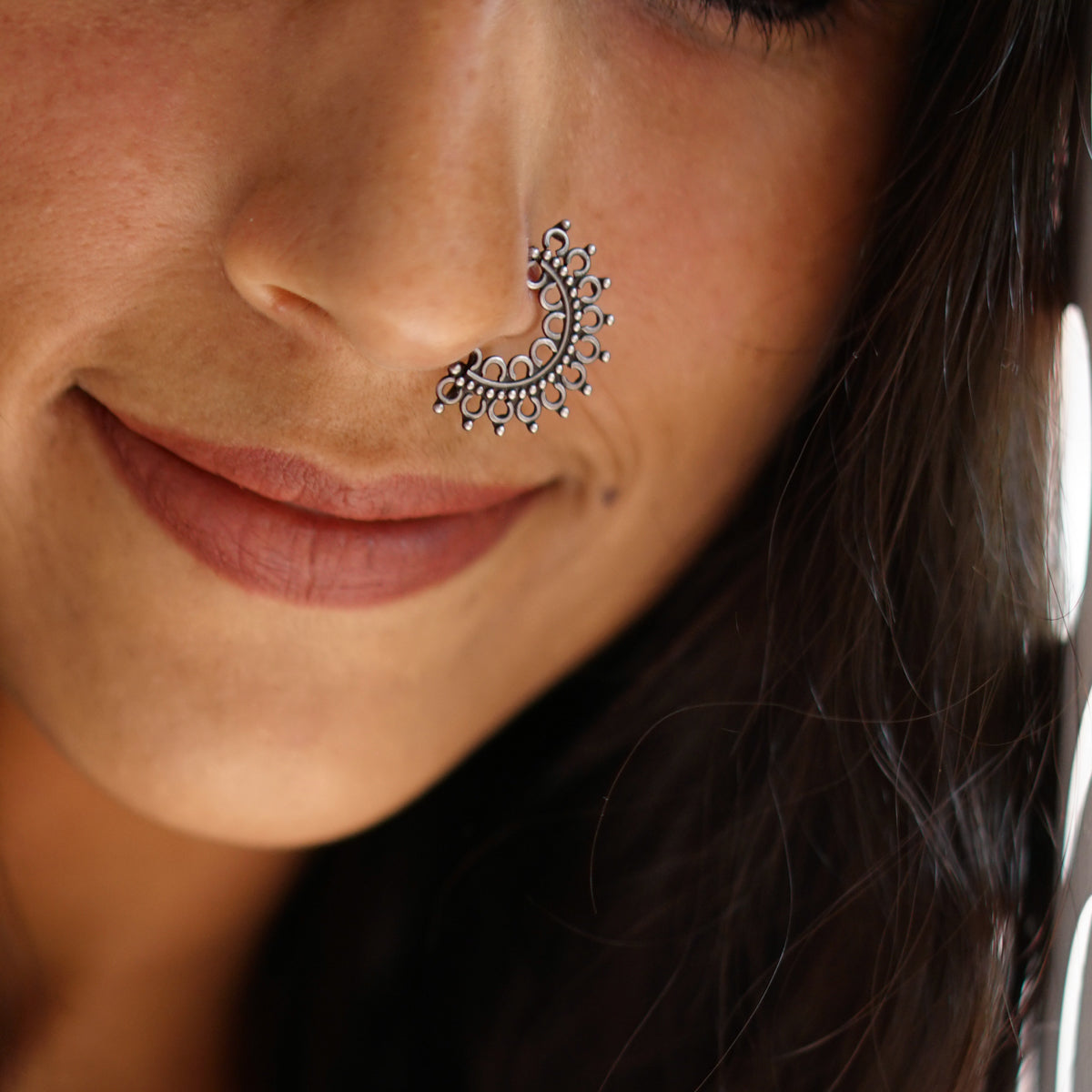 a close up of a woman with a nose piercing