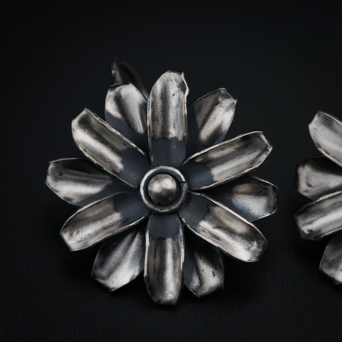 a pair of metal flowers on a black surface